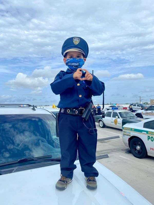 A little kid wearing security staff uniform with matching mask